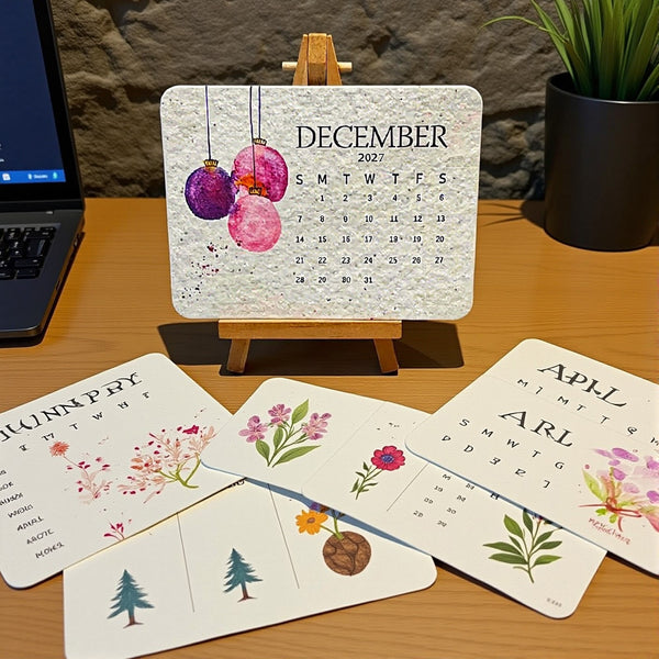 2027 desk calendar on its stand with monthly flower cards spread in front