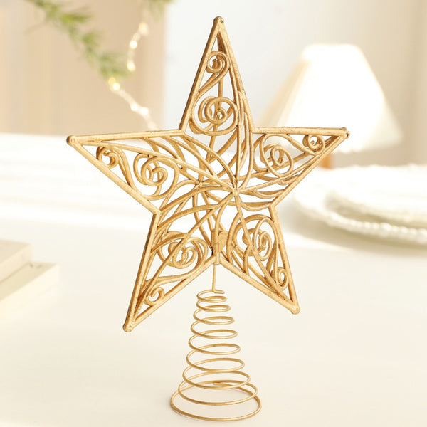 Gold filigree star tree topper on a white table