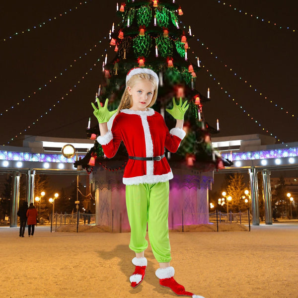 Girl in the green grump Christmas costume in front of a lit Christmas tree