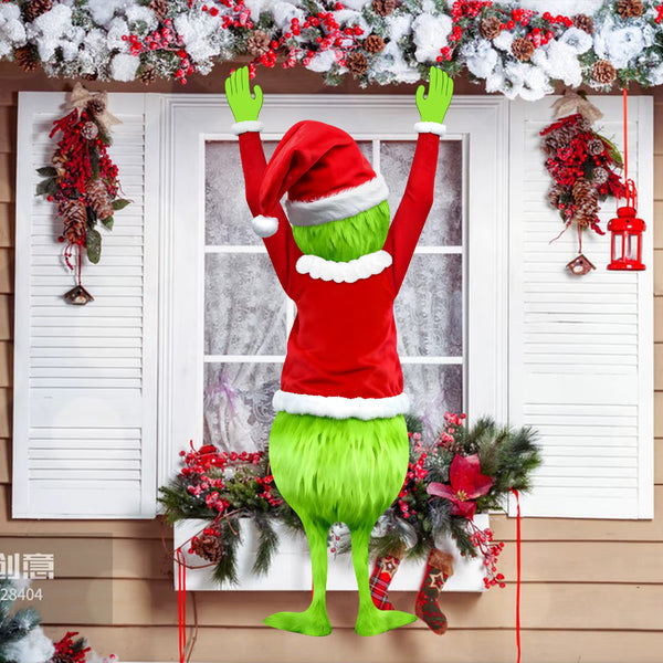 Green furry legs and Santa suit wall hanging on a window with wreaths and garlands