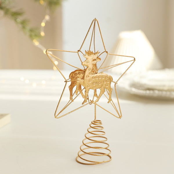 Gold reindeer star tree topper on a white table