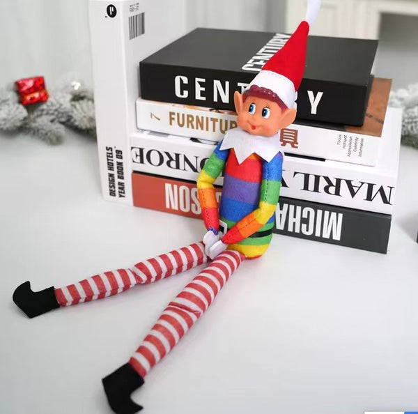 Rainbow Christmas elf doll sitting on a stack of books