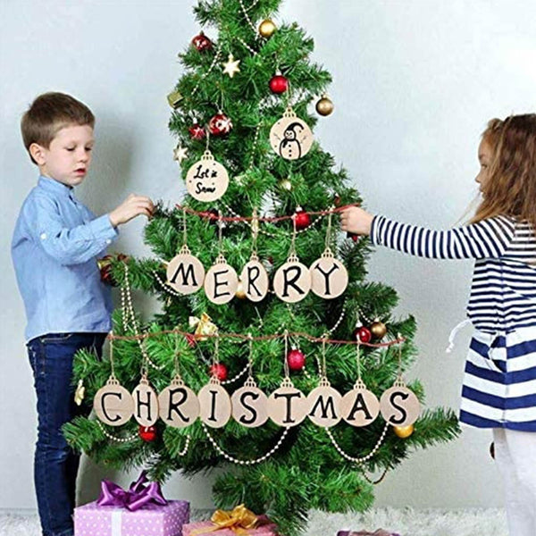 Children hanging round wooden ornaments spelling Merry Christmas