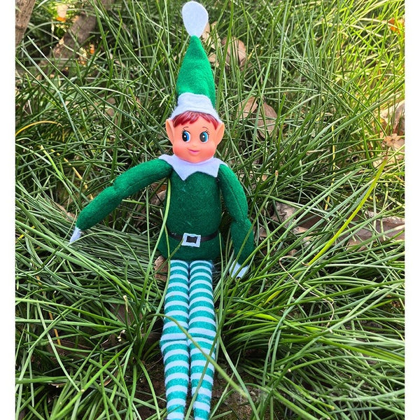 Green girl Christmas elf doll with striped legs on grass