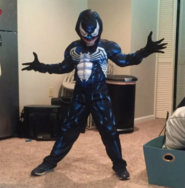 Child wearing Venom costume with arms spread indoors