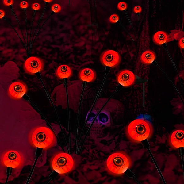 Swaying eyeball solar lights grouped as a Halloween yard feature