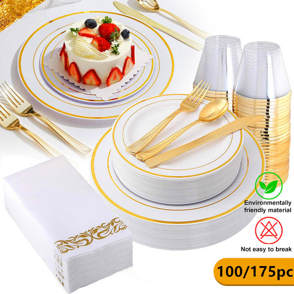 Gold rimmed party plates, cutlery, cups and napkins set with a cake