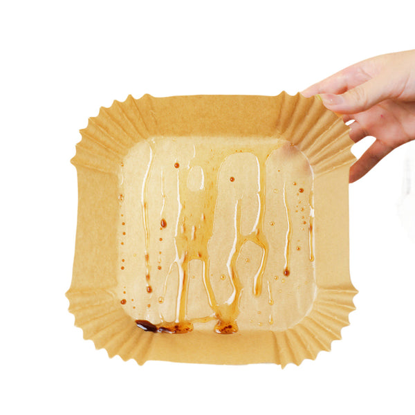 Used air fryer liner showing oil caught on the paper