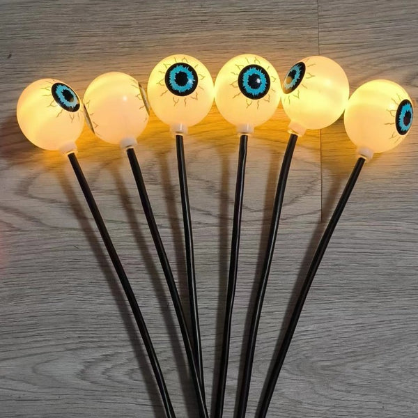 Multi colour solar eyeball lights glowing along a front path