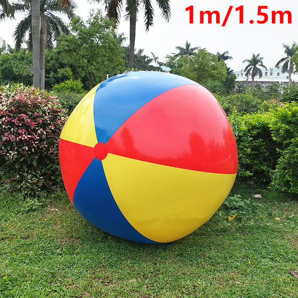 Giant inflatable beach ball on grass with palm trees