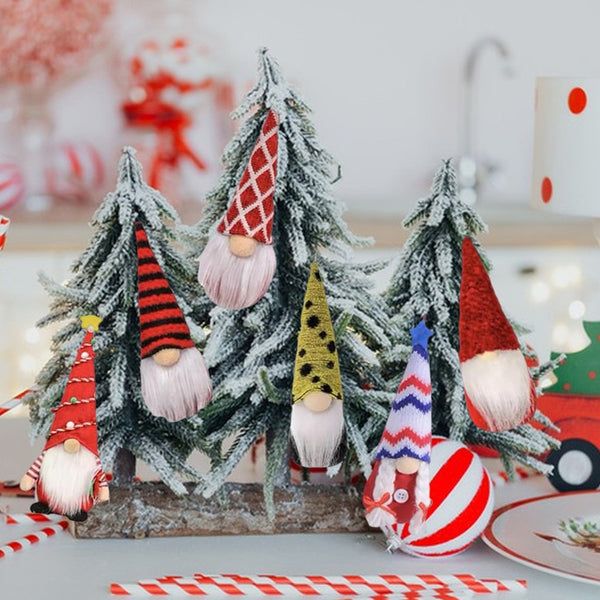 Plush gnomes with red, yellow and blue patterned hats among mini Christmas trees