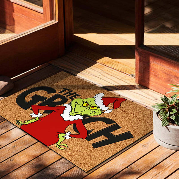 Green grump Christmas doormat on a timber deck