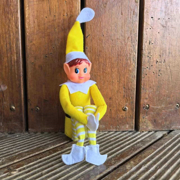 Yellow girl Christmas elf doll sitting on a deck