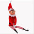 Red boy Christmas elf doll with striped legs sitting with its legs crossed