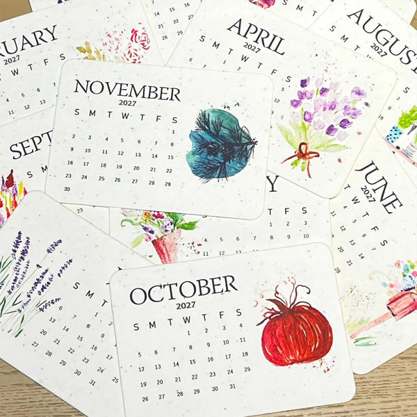 Illustrated monthly seed paper calendar cards fanned out
