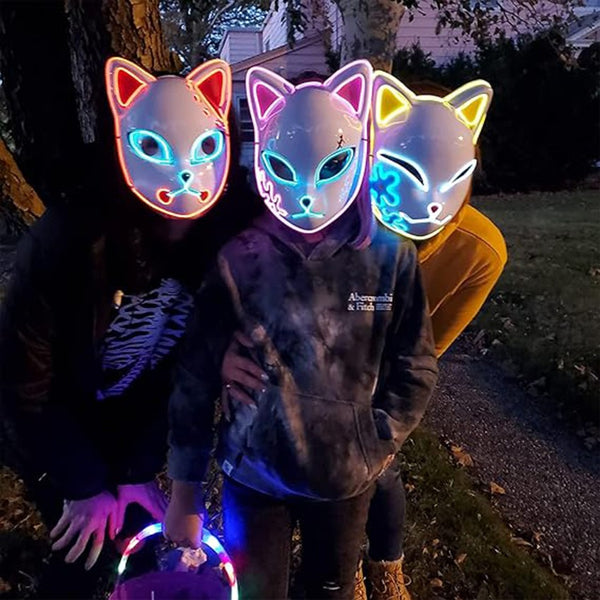 Friends wearing glowing kitsune masks outdoors at night for Halloween