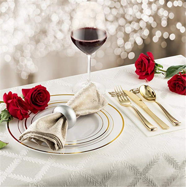 Gold cutlery and napkin on a wedding table with roses