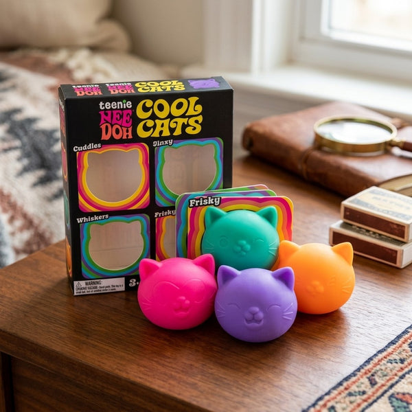 Four mini squishy cats out of the box on a wooden table