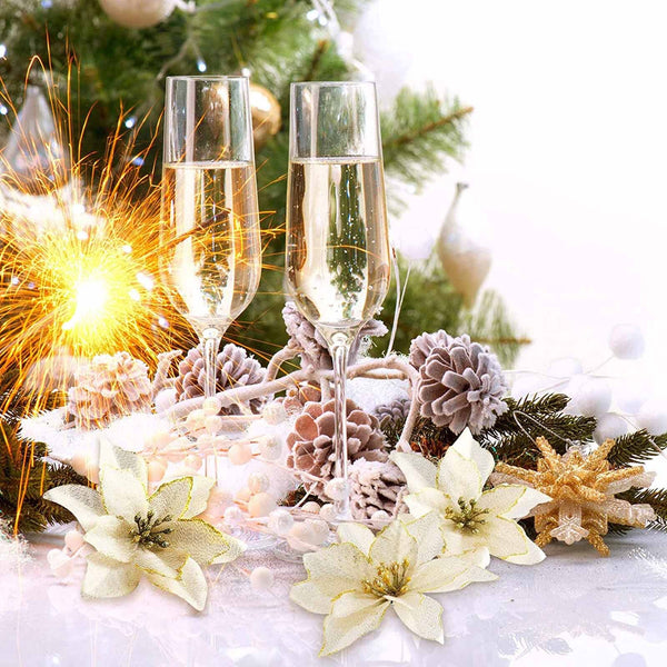 Gold and white poinsettias on a Christmas table with champagne glasses