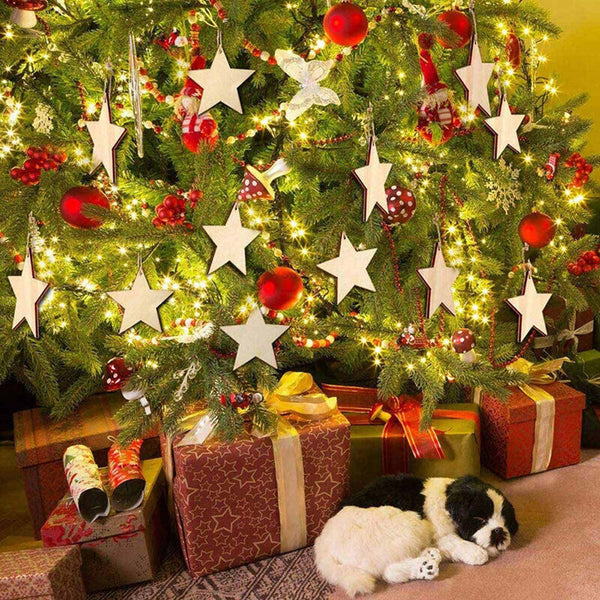 Wooden star ornaments hanging on a lit Christmas tree