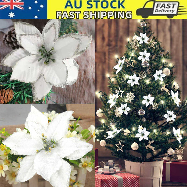 Glitter poinsettia Christmas flowers on a white-decorated Christmas tree