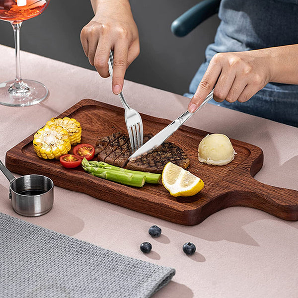 Cutting steak with gold plastic cutlery