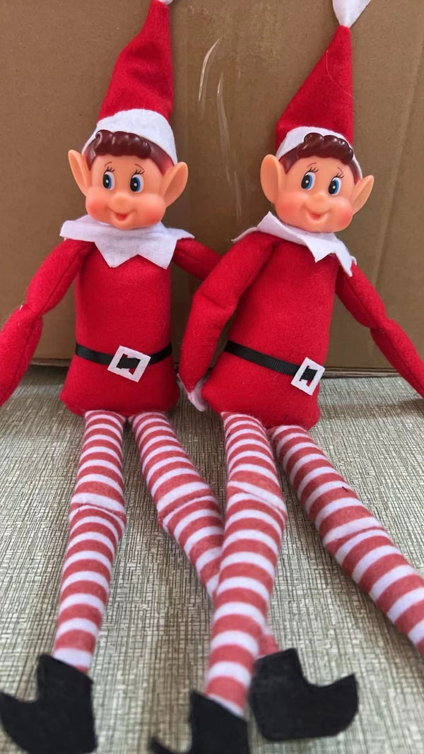 Two red Christmas elf dolls sitting side by side with their legs out