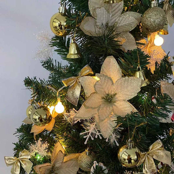 Gold poinsettia flowers on a Christmas tree with gold baubles
