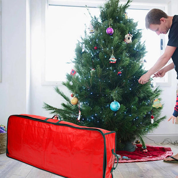 Red wrapping paper storage bag standing beside a Christmas tree