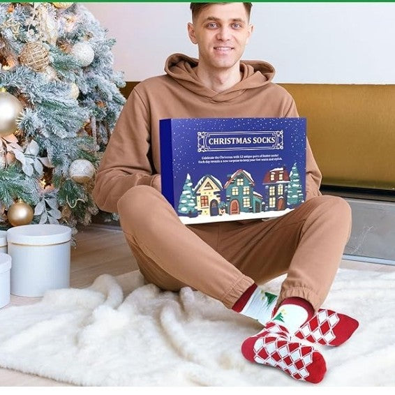 Man sitting by a Christmas tree with a sock advent calendar