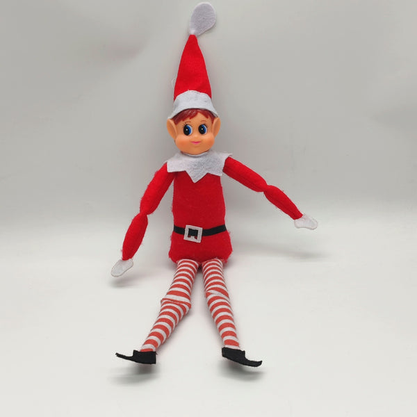 Red girl Christmas elf doll sitting on a white shelf