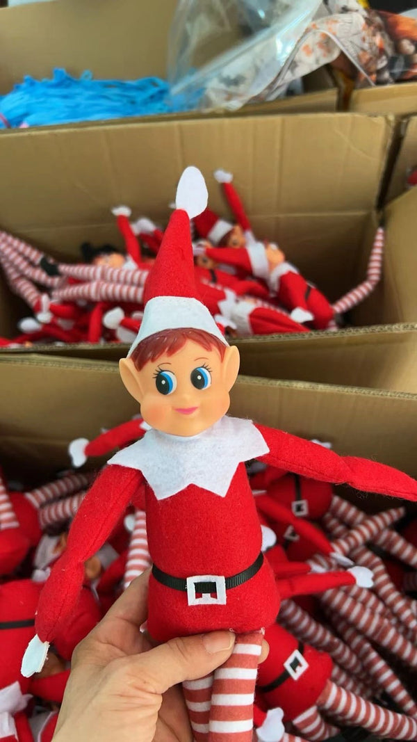 Red Christmas elf doll held above the stock carton
